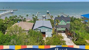 A coastal property with multiple houses, a pier, and a beach view.