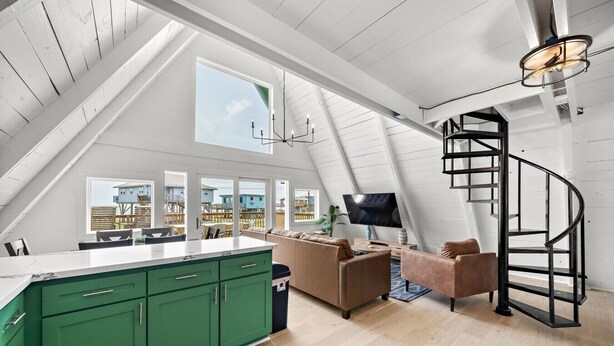 Ein modernes Loft mit Küche, Wohnbereich und einer Wendeltreppe.
