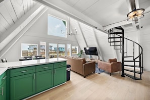 Un loft moderno con cocina, sala de estar y una escalera en espiral.