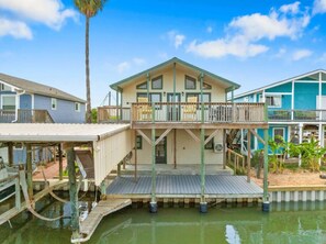 A waterfront property with a main house and two additional structures, connected by a dock.