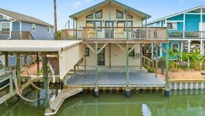 A waterfront property with a main house and two additional structures, connected by a dock. - Canal Home with Two Docks and Large Gameroom (Surfside)