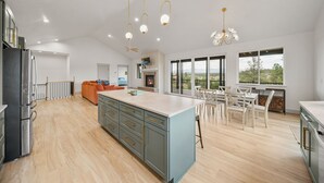 Een ruime keuken met een centraal eiland, moderne apparatuur en een eetgedeelte met uitzicht.