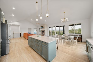 A spacious kitchen with a central island, modern appliances, and a dining area with a view. - Luxury Home on 5 Acres / Unreal Views! / Hot Tub! (Pagosa Springs)