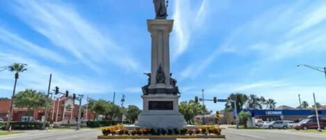 A statue on a pedestal with a clear sky in the background.
