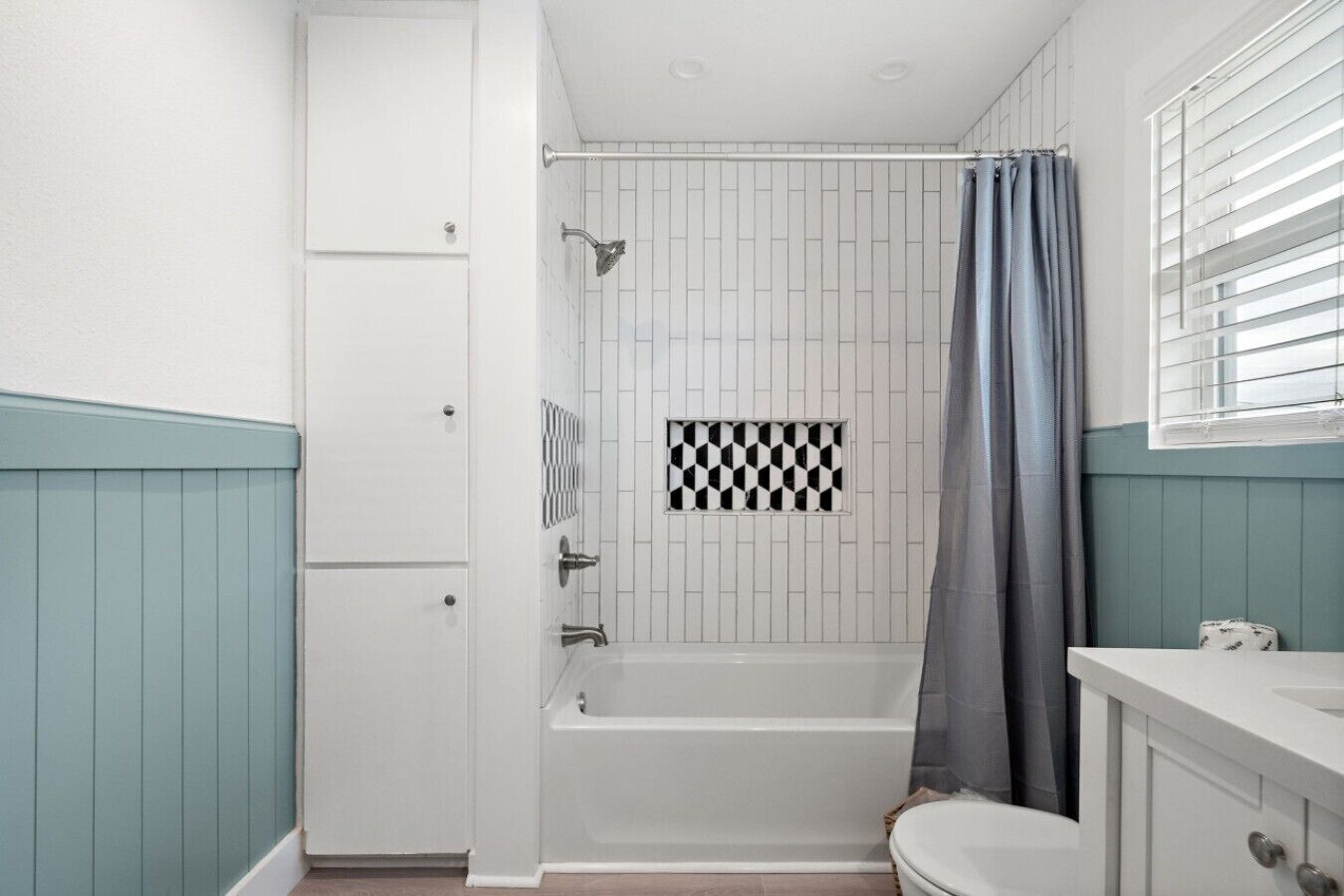 A bathroom with a shower, toilet, and sink.