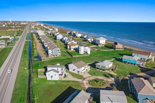 Zona residencial costera con casas, una carretera y una playa.