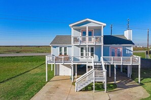 A two-story house with a balcony, a garage, and a visible address number. - Stunning Beach House, Ocean Views & Spacious Deck (Galveston)