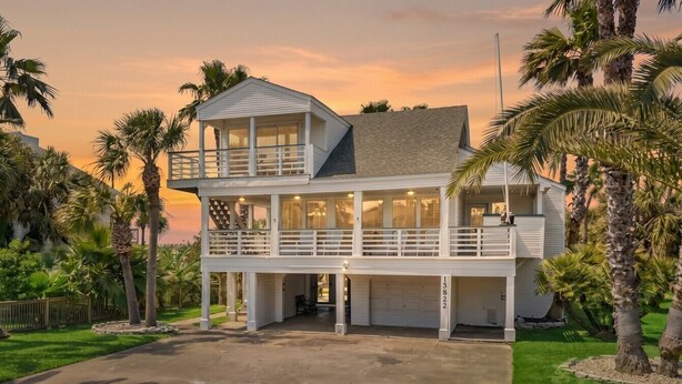 A two-story house with a balcony, a garage, and a driveway. - Texas Vacation Home with Pool, Near the Beach (Galveston)