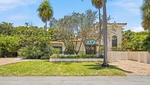 A residential property with a paved driveway, a well-maintained lawn, and a variety of tropical plants. - Heated Pool, Sunny Oasis, 4 bedroom, 9 beds, 4 bathrooms (Fort Lauderdale)