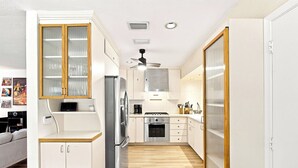 A compact kitchen with a refrigerator, stove, and microwave. - Heated Pool, Sunny Oasis, 4 bedroom, 9 beds, 4 bathrooms (Fort Lauderdale)