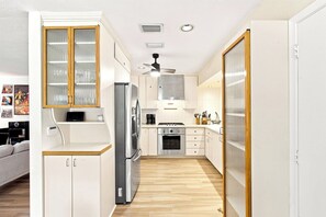 A compact kitchen with a refrigerator, stove, and microwave. - Heated Pool, Sunny Oasis, 4 bedroom, 9 beds, 4 bathrooms (Fort Lauderdale)