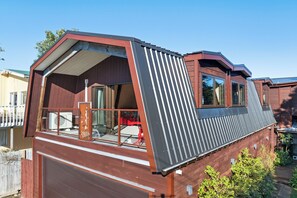 Ein modernes Wohnmobil mit großem Stauraum, überdachter Terrasse und geneigtem Dach.