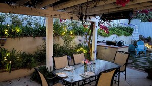 An outdoor patio with a table set for dining, surrounded by chairs, and decorated with string lights and plants. - Charming 3-bedroom house in amazing Hollywood Riviera section of Redondo Beach (Redondo Beach)
