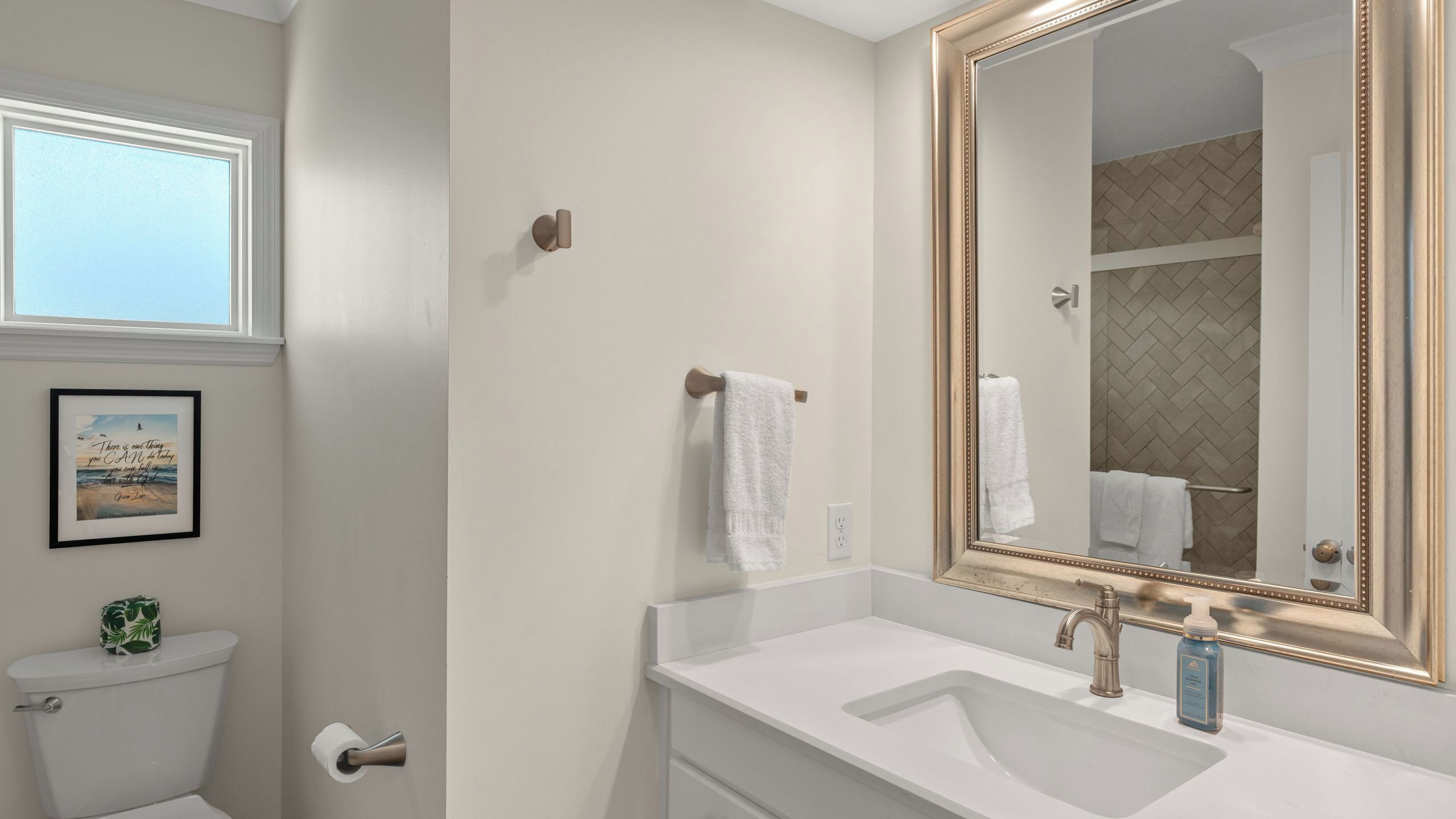 Ein Badezimmer mit Toilette, Waschbecken, Spiegel und Handtuchhalter.