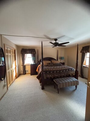A four-poster bed with a canopy, a ceiling fan, and a window with curtains. - Log Cabin - Hot Tub - Near Kalahari & Camelback (Newfoundland)