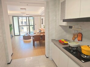 Een moderne keuken met een fornuis, een spoelbak en een eethoek met een tafel en stoelen.