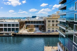 Ein Gebäude an der Uferpromenade mit Glasfassade, Innenhof und Bootsanleger.