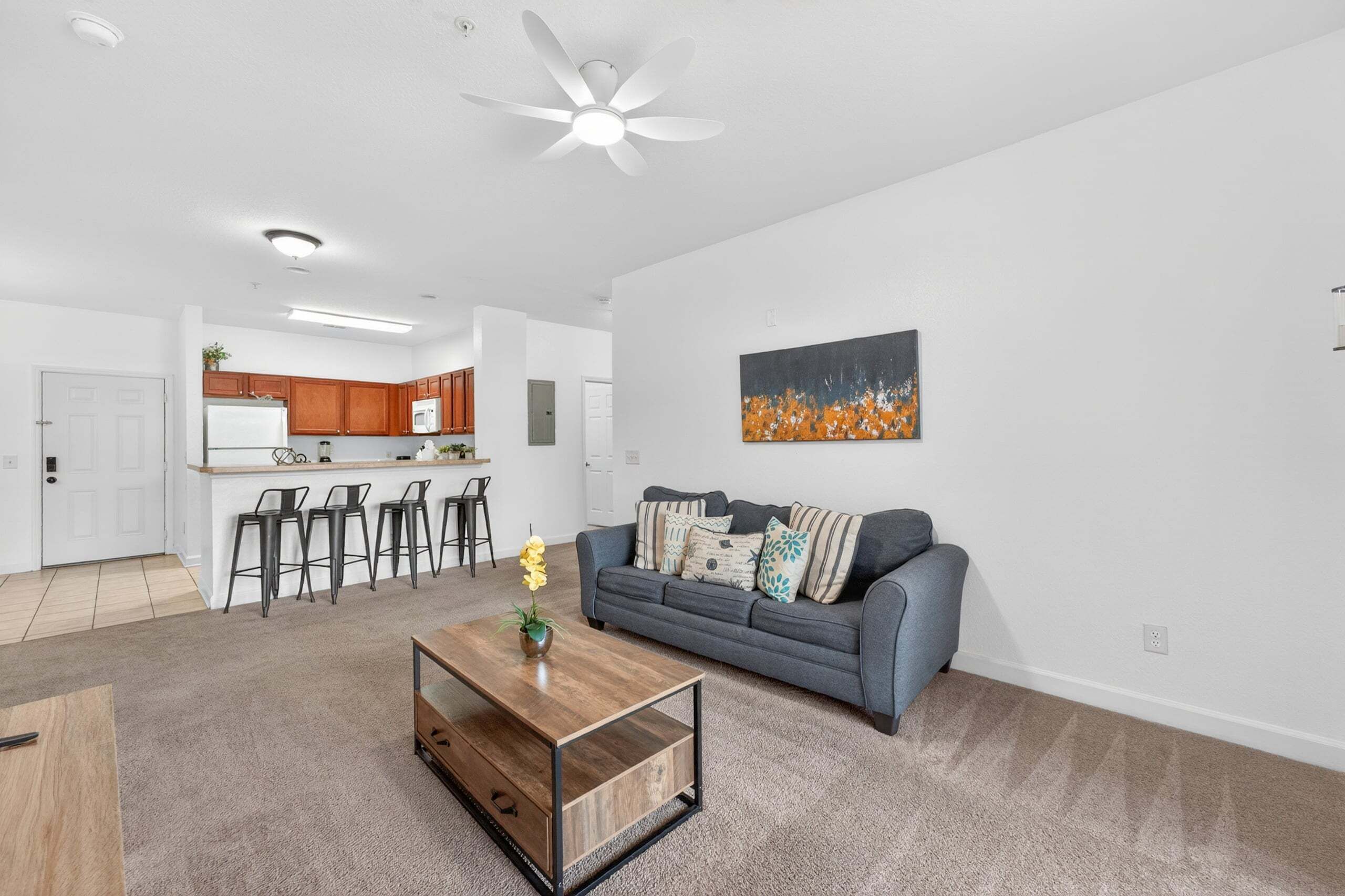 A modern living room with a sofa, coffee table, and artwork on the wall.