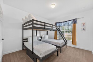 Ein Schlafzimmer mit Etagenbetten, einem Fenster, einer Tür und einer Deckenleuchte.