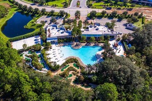 Eine Vogelperspektive eines Resorts mit großem Pool, Golfplatz und umgebender Vegetation.