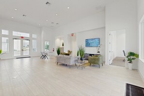 A spacious, modern interior with a seating area, a flat-screen TV, and a staircase leading to another level. - Two-story Townhouse With Private Pool, Screened Lanai, Washer/dryer (Davenport)