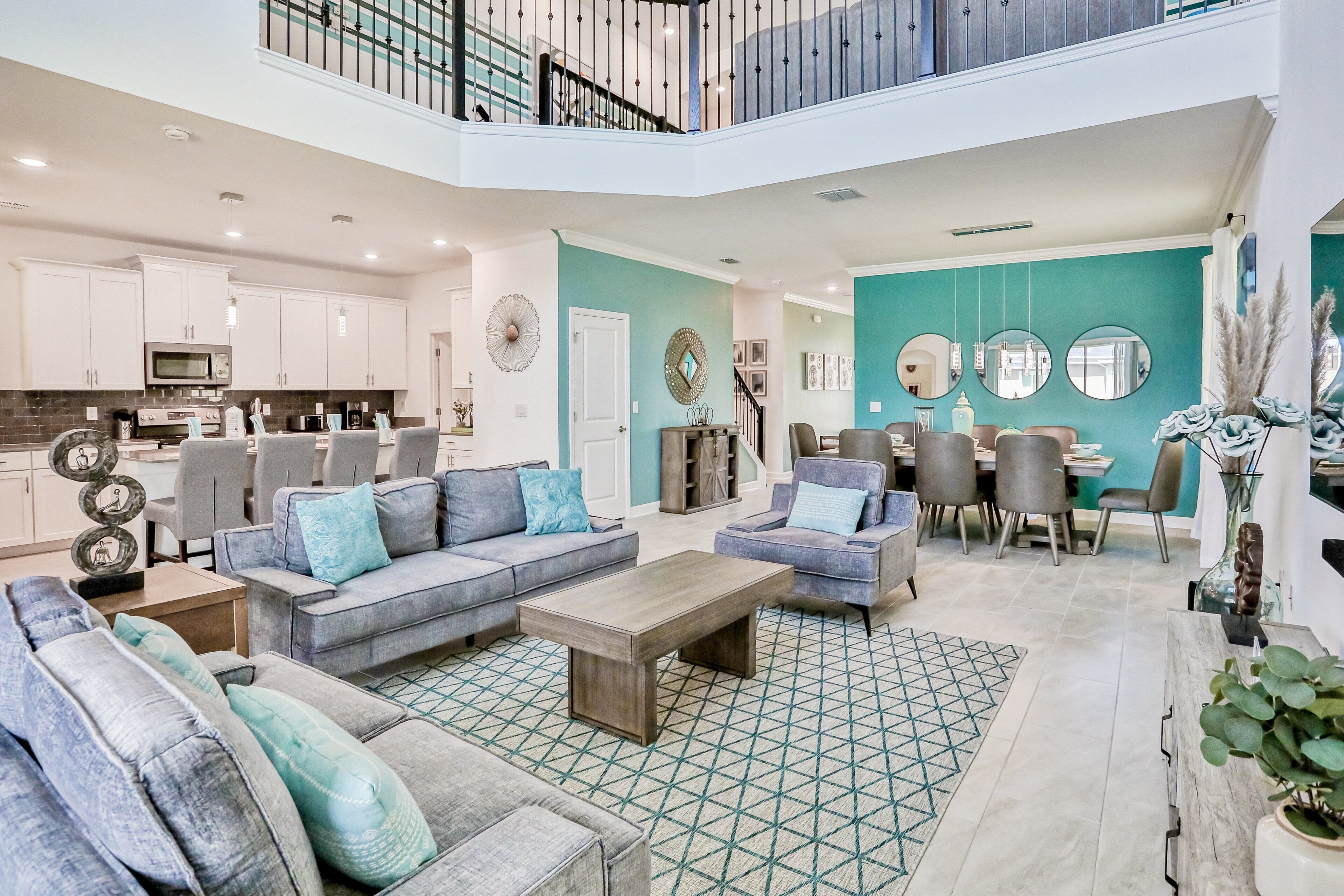 A spacious living area with a dining table, sofas, and a kitchen in the background.