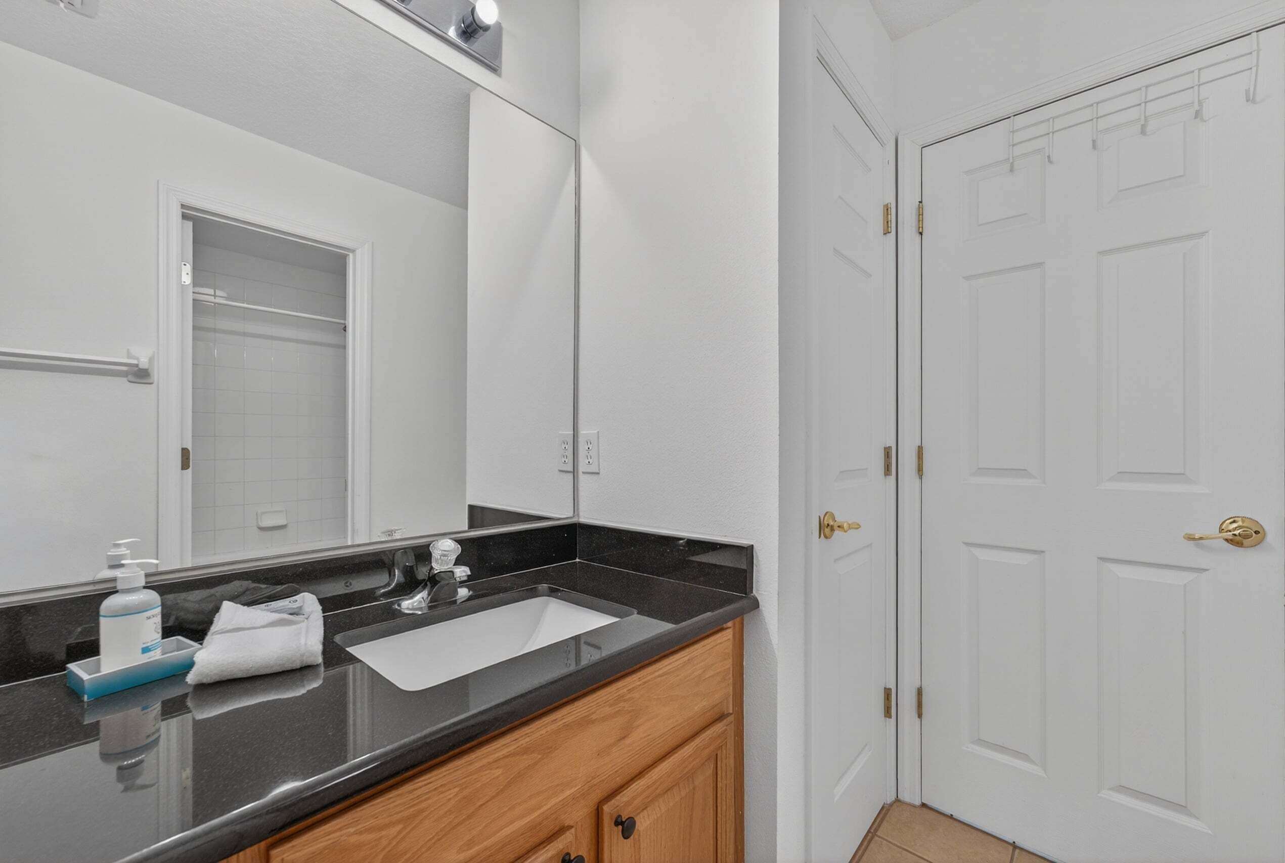 A bathroom with a mirror, sink, and towel rack.