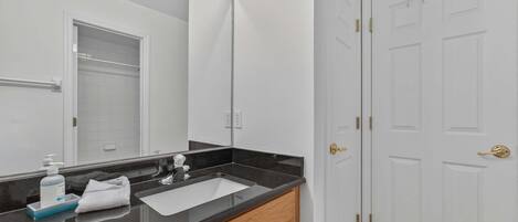 A bathroom with a mirror, sink, and towel rack.