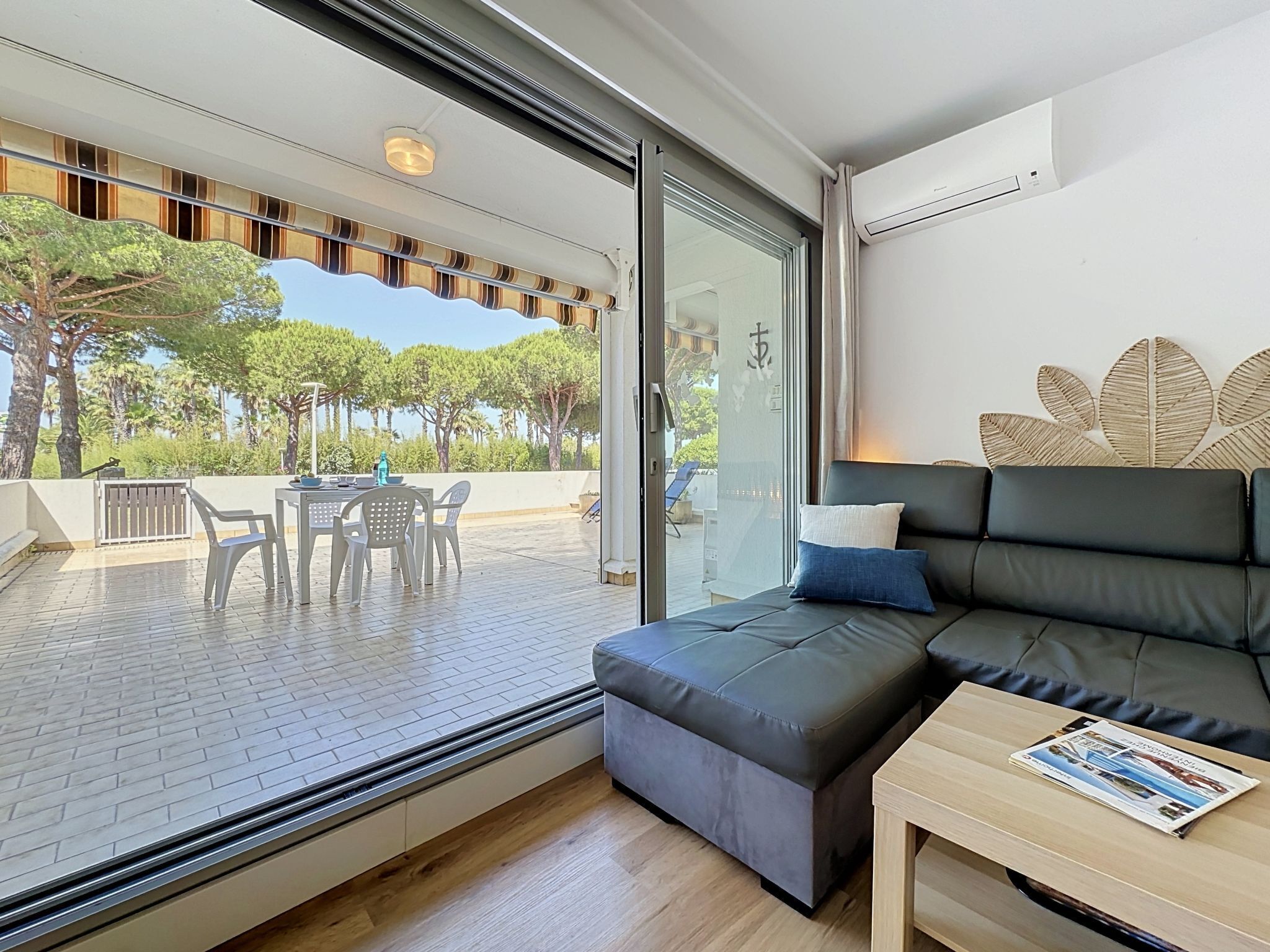 A modern living room with a sofa, a small table, and a view of the outdoors.