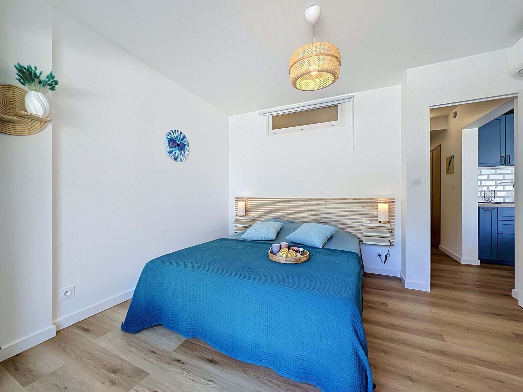 Quarto com cama, mesa de cabeceira e ar condicionado fixado na parede.