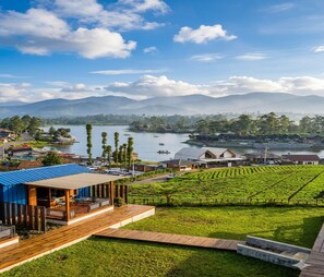 A coastal property with a wooden deck, a vineyard, and a view of the sea and mountains.