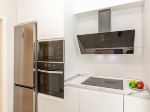Eine moderne Küche mit Einbauofen, Mikrowelle und Kühlschrank aus Edelstahl.