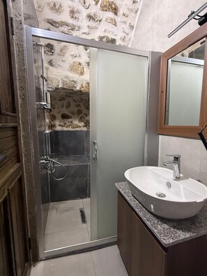Ein Badezimmer mit Dusche, Waschbecken und Spiegel.