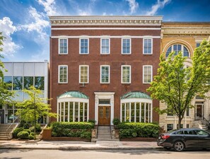 A brick building with a central entrance, large windows, and a car parked in front. - Luxury Queen Studio - Solara at The Marle Boutique Hotel-Near JHU + Downtown (Baltimore)