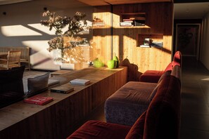 Una sala moderna con una mesa de centro de madera, un sofá y una planta en maceta.