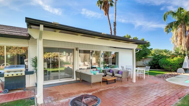 A covered patio with a grill, outdoor seating, and a fire pit. - Scottsdale Oasis Diving Pool, Game Room & 4BR Near Old Town & Mayo Clinic (Scottsdale)