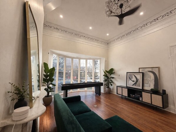 A modern living room with a pool table, green sofa, and a console table with artwork. - Amour Luxury King Suite w/ Soaking Tub - Boutique Hotel Near Johns Hopkins & DT (Baltimore)