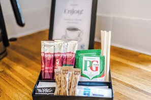 Eine Auswahl an Kaffeepads, Teebeuteln und PG Tips Teebeuteln auf einer Holztischplatte.
