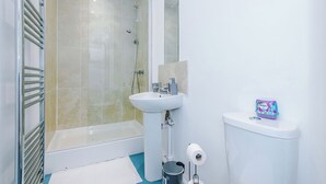 Ein Badezimmer mit Duschkabine, Waschbecken in Weiß und Toilette.