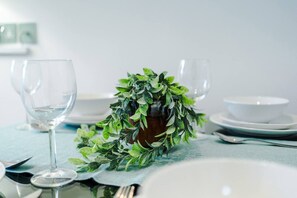 A dining table set with clear glassware, a bowl, and a decorative plant arrangement. - 4 Guests | 1 Double bed and Sofa Bed (Merseyside)