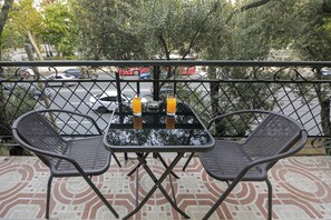 A balcony with two chairs and a table, a glass of orange juice, and a metal bowl. - Family Friendly 2BR  w/Balcony - Steps from Old city - 4 min Walk to Nizami (Baku)