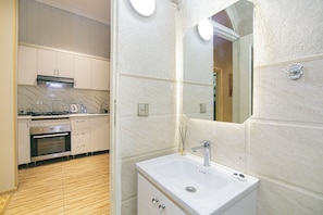 A modern kitchen with a built-in oven, a stove, and a microwave. - Family Friendly 2BR  w/Balcony - Steps from Old city - 4 min Walk to Nizami (Baku)