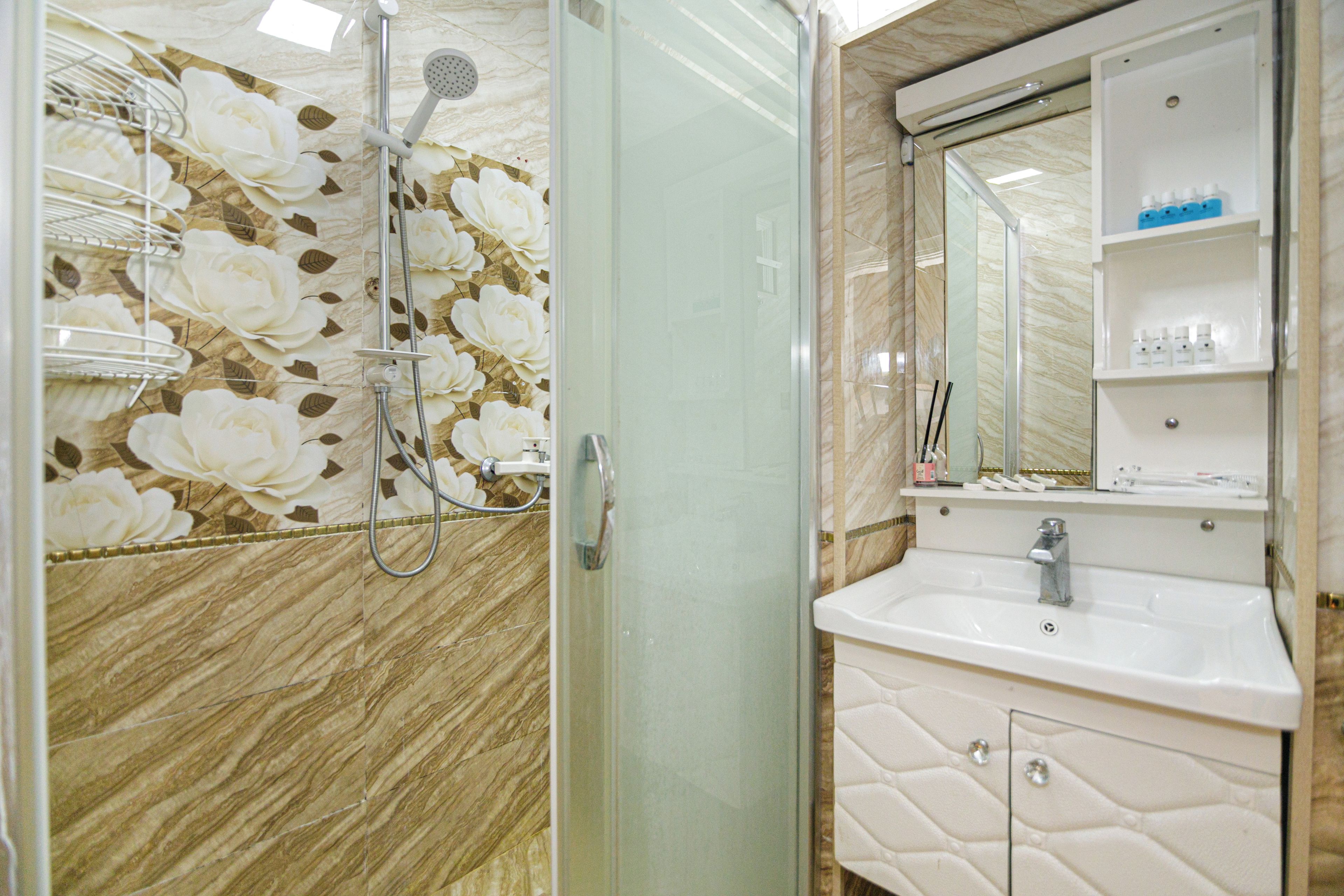 A bathroom with a shower, a sink, and a mirror.