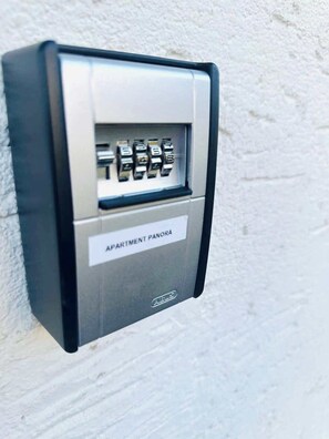 Een aan de muur bevestigd intercomsysteem met een keypad en een label waarop 'APARTMENT PANORA' staat.