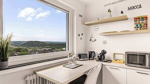A modern kitchen with a view, a coffee station, and a dining area.