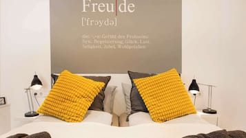 Ein Schlafzimmer mit einem Bett, zwei Lampen und einer Wand mit Schrift.