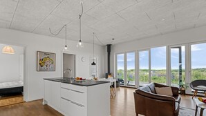 Una cocina moderna con una isla central, un comedor con vistas y una zona de estar acogedora.