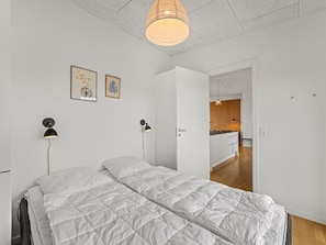 Ein Schlafzimmer mit einem Bett, Nachttischlampen und einer Hängeleuchte.