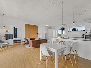 Eine moderne Küche mit Essbereich, Holzboden und Blick ins Freie.