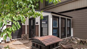 Uma casa moderna com base de pedra, deck de madeira e telhado de metal.